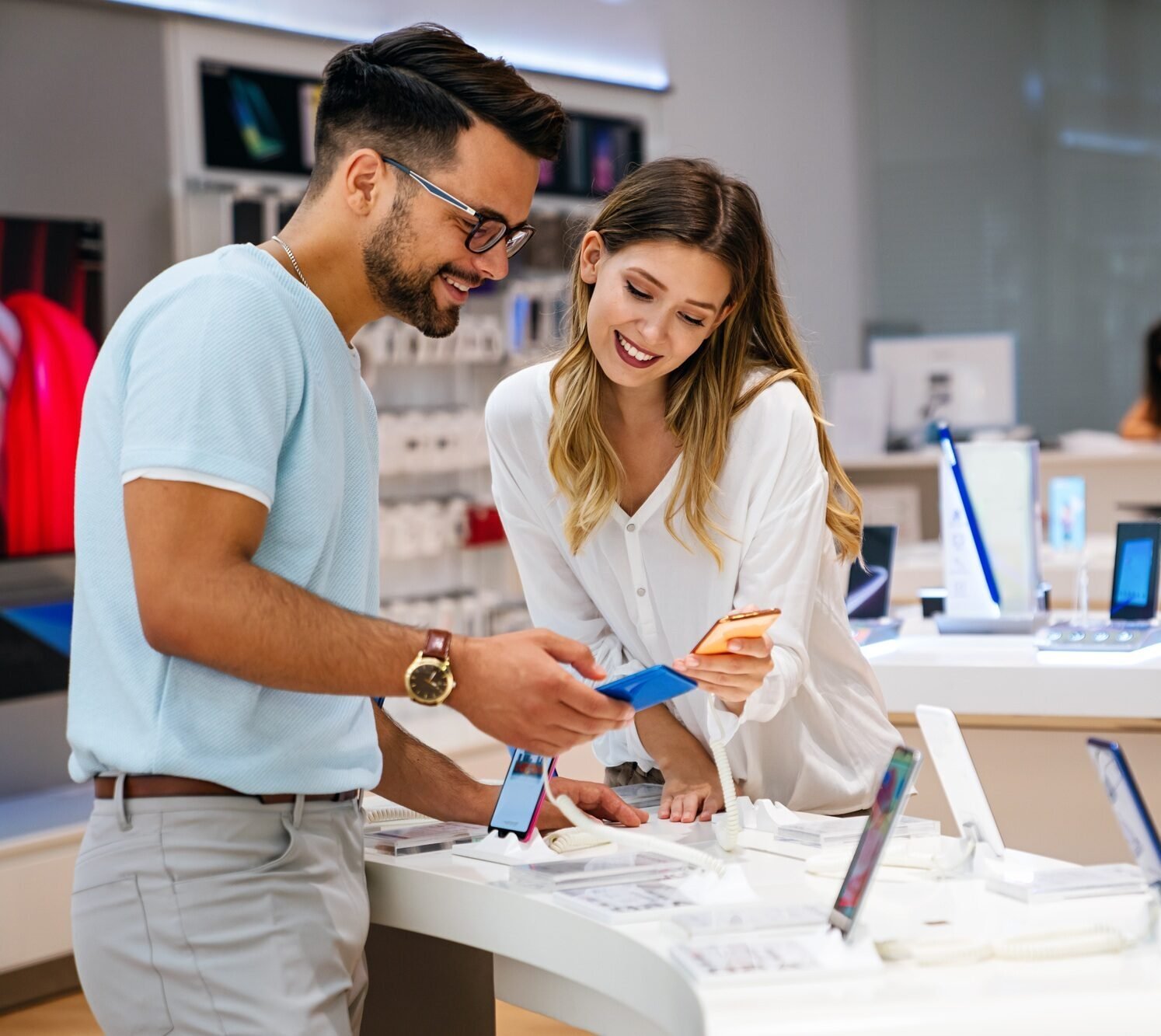 Shopping a new digital device. Happy couple buying a smartphone in store